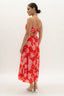 Woman wearing a red floral dress on a white background