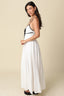 Back view of the Santorini Contrast Tie Maxi Dress in white, highlighting the open back design, smocked panel, adjustable black spaghetti straps with hardware, and full flowing skirt