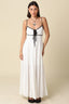 Full front view of the Santorini Contrast Tie Maxi Dress in white with black contrast detailing, showing the complete silhouette from neckline to hem with front tie and flowing woven cotton fabric