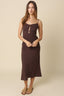 Woman wearing a brown dress against a beige background