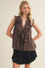 Woman wearing a brown ruffled top and black skirt on a beige background