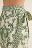 Green and white patterned skirt with a tie waist on a neutral background