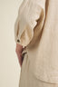 Close-up of a beige shirt with a button on a beige background