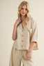 Woman wearing a beige outfit with a plain background
