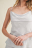 Woman wearing a light blue peplum top and skirt on a beige background