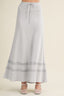 Light blue maxi skirt with lace trim on a beige background