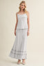 Light blue maxi skirt with lace trim on a beige background