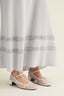 Light blue maxi skirt with lace trim on a beige background