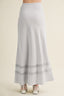 Light blue maxi skirt with lace trim on a beige background