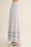 Light blue maxi skirt with lace trim on a beige background