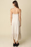 Woman wearing a beige slip dress with a plain background