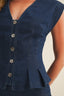 Blue denim vest with buttons on a neutral background