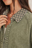 Green denim jacket with a checkered collar worn by a person