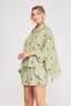 Woman wearing a light green outfit with a pattern on a white background