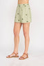 Person wearing light green shorts with a subtle pattern on a white background