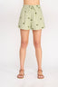 Green shorts with floral pattern worn by a person on a white background