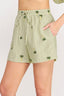 Green shorts with palm tree patterns on a plain background