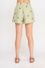 Light green shorts with floral pattern worn by a person on a white background