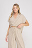 Woman wearing a beige polka dot jumpsuit on a white background