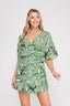 Woman wearing a green leaf-patterned dress on a white background