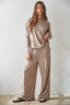 Person wearing a beige lounge set against a plain background