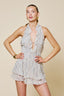 Woman wearing a light-colored ruffled dress against a beige background