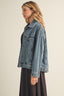 Woman wearing a denim jacket on a plain background