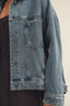 Close-up of a blue denim jacket on a plain background