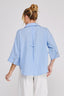 Person wearing a light blue checkered shirt with rolled-up sleeves on a white background