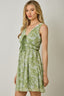 Woman wearing a green floral dress against a plain background