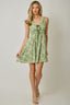 Woman wearing a green floral dress against a plain background