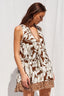 Woman wearing a brown and white floral dress against a white background