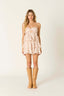 Woman wearing a strapless dress with cut-out details and tan boots on a white background