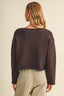 Back view of the Driftwood Bateau Neck Crop Sweater in dark espresso brown, showing the clean boxy silhouette, dropped shoulder construction, long sleeves, and rolled-edge hem finishing