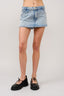 Denim skirt worn by a person on a plain background