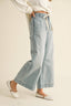 Light blue denim pants worn by a person on a beige background