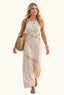 Woman in a coastal beige halter cut out maxi dress