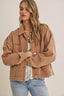 Woman wearing a brown jacket with a plain background