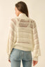 Woman wearing a cream knitted sweater and jeans on a beige background