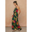 Woman wearing a colorful floral dress against a beige background
