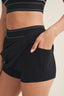Person wearing black athletic shorts on a beige background
