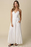 Woman wearing a white dress against a beige background