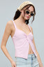 Woman wearing a pink top and sunglasses with a neutral background