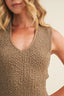 Close-up of a textured beige sleeveless top worn by a person.