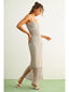 Woman wearing a light gray dress with a textured pattern on a white background