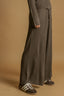 Person wearing a ribbed knit outfit with wide-leg pants on a beige background