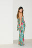 Woman wearing a colorful floral jumpsuit against a white background