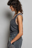 Woman wearing a sleeveless top and pants against a plain background