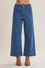 Blue jeans worn by a person on a beige background
