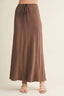 Brown maxi skirt worn by a person on a beige background
